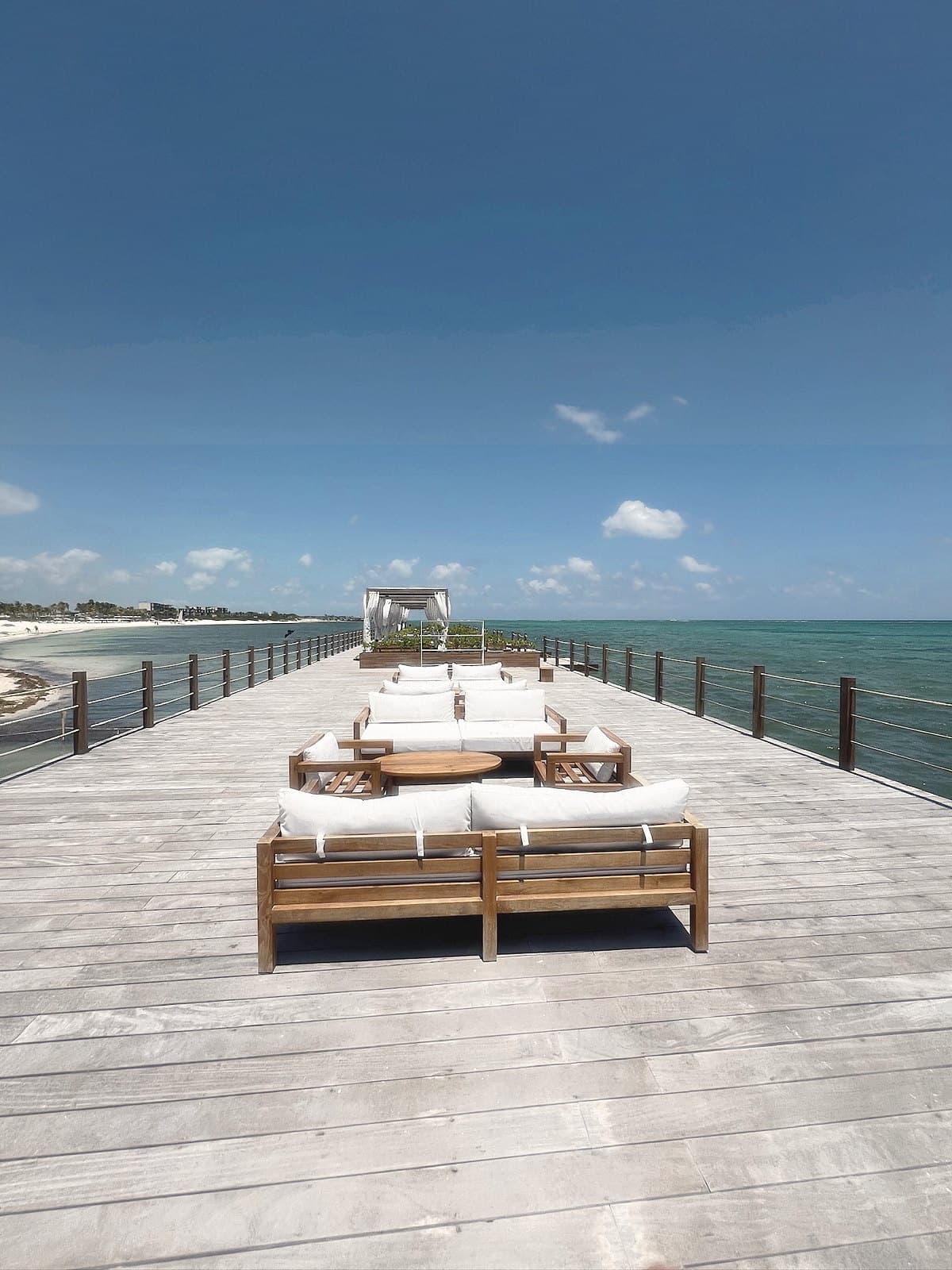 Daybeds on a wooden pier over the sea under a blue sky
